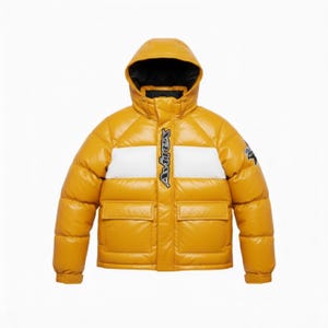 May include: Mustard yellow puffer jacket with a hood and two front pockets. The jacket features a white stripe across the chest with the brand name in black. A small logo is on the upper left sleeve. The jacket is designed for cold weather.