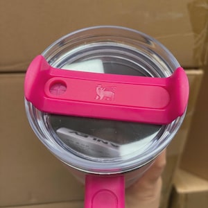 May include: A white ceramic mug with a black handle and the text "But First, Coffee" in a black, bold font. The mug is on a white surface.