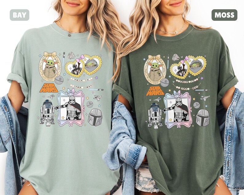 Puede incluir: Dos camisetas, una en verde bah&iacute;a y otra en verde musgo, cada una con gr&aacute;ficos de Star Wars. Los dise&ntilde;os incluyen personajes como Grogu, Darth Vader y R2-D2, enmarcados en elementos decorativos. El logo de Star Wars tambi&eacute;n es visible.