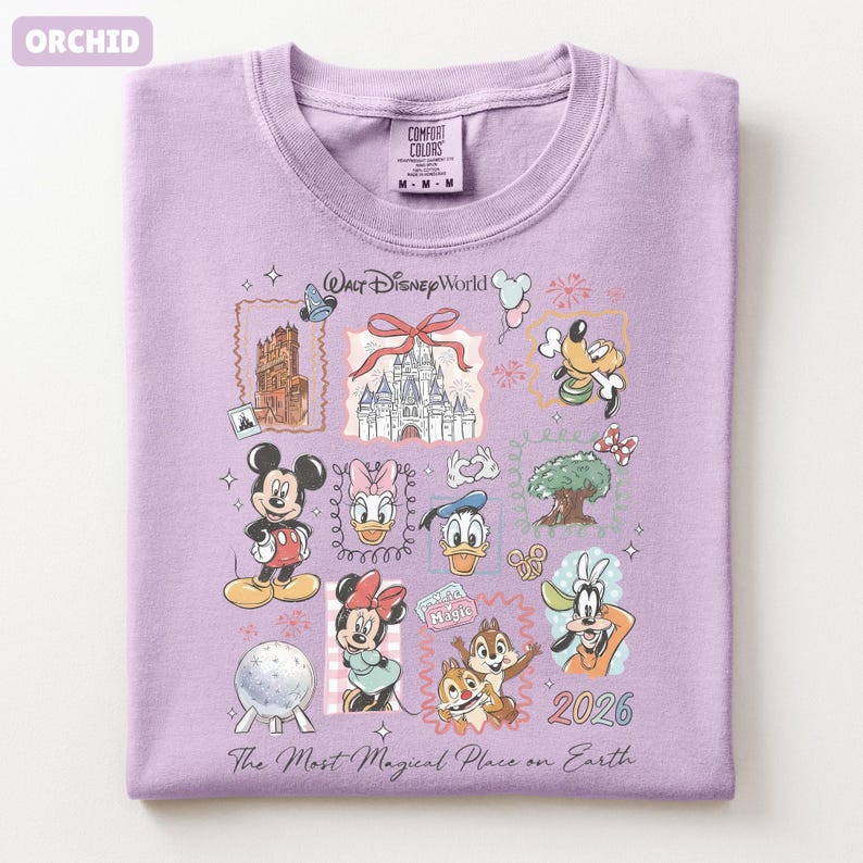 May include: Orchid-colored t-shirt featuring a collage of Disney World graphics. The design includes Mickey Mouse, Minnie Mouse, Donald Duck, and other characters, along with the text "Walt Disney World" and "2026". The shirt is made of Comfort Colors material.