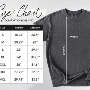 May include: A dark grey Comfort Colors 1717 t-shirt with a size chart. The chart lists sizes S to 4XL, with corresponding width and length measurements in inches. The shirt's width and length are indicated with white lines.