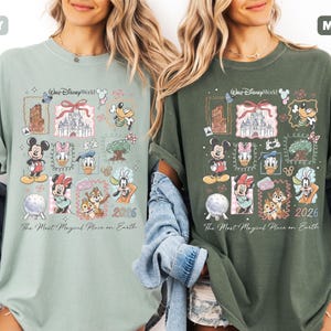 May include: Two t-shirts, one in bay green and the other in moss green, each featuring a colorful Disney World graphic. The design includes various Disney characters, a castle, and the text "The Most Magical Place on Earth" and "2026".