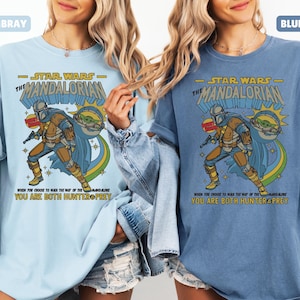 以下が含まれることがあります： スターウォーズのマンダロリアンデザインのライトブルーとブルージーンズのTシャツ。デザインにはマンダロリアンとグローグーが含まれており、「WHEN YOU CHOOSE TO WALK THE WAY OF THE MANDALORIAN, YOU ARE BOTH HUNTER & PREY」というテキストがあります。