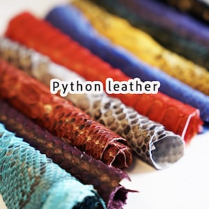 Puede incluir: Una colecci&oacute;n de cuero de pit&oacute;n enrollado en varios colores, incluyendo turquesa, marr&oacute;n, rojo y azul. La imagen est&aacute; etiquetada como "Python leather". El cuero tiene una apariencia texturizada y escamosa.