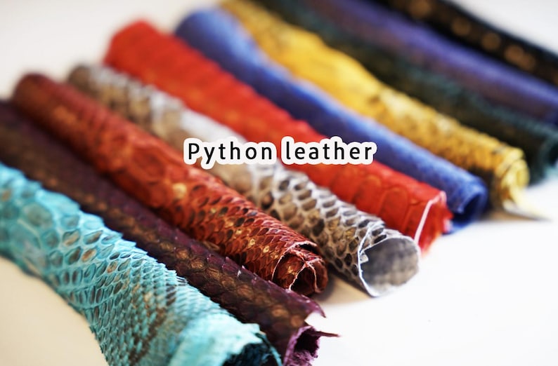 Puede incluir: Una colecci&oacute;n de cuero de pit&oacute;n enrollado en varios colores, incluyendo turquesa, marr&oacute;n, rojo y azul. La imagen est&aacute; etiquetada como "Python leather". El cuero tiene una apariencia texturizada y escamosa.