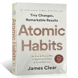 Peut inclure: Un livre &agrave; couverture rigide intitul&eacute; "Atomic Habits" de James Clear. La couverture est blanche avec le titre en grandes lettres marron pix&eacute;lis&eacute;es. Le texte "Tiny Changes, Remarkable Results" est au-dessus du titre. Le livre est emball&eacute; dans du plastique transparent.