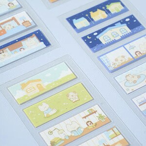 Puede incluir: Una hoja de pegatinas decorativas con varias ilustraciones. Las pegatinas representan escenas con casas, osos y otros elementos lindos. La paleta de colores incluye azules, verdes, amarillos y marrones, creando una estética caprichosa y acogedora.