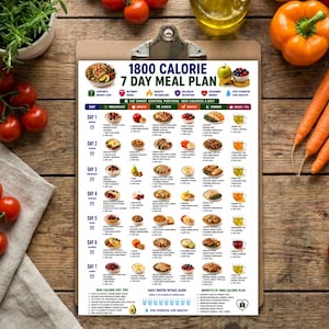 Peut inclure: Un plan de repas de 1800 calories sur 7 jours imprim&eacute; sur un presse-papier, pr&eacute;sentant une mise en page en grille avec des ic&ocirc;nes d'aliments, des descriptions de repas et des calories pour chaque moment de la journ&eacute;e, ainsi qu'un guide d'hydratation.
