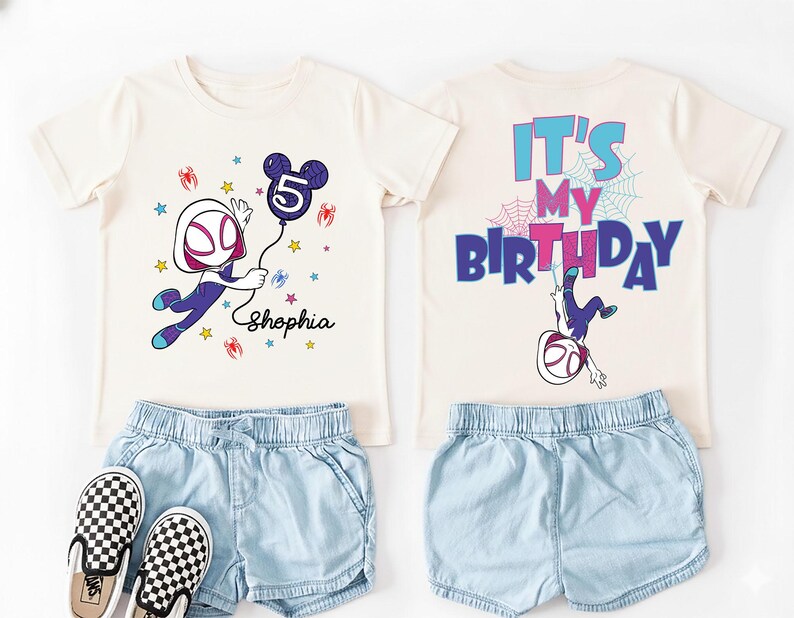 May include: A cream-colored t-shirt with a graphic of a superhero holding a number 5 balloon, paired with denim shorts and checkered sneakers. The back of the shirt says "It's My Birthday".