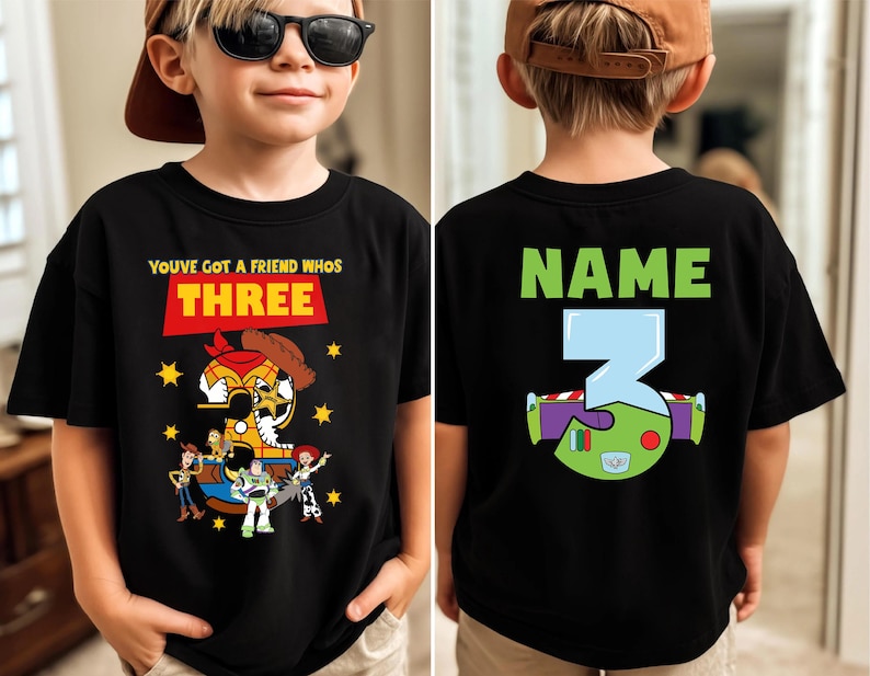 May include: Black t-shirt with a colorful graphic featuring characters and text from the movie "Toy Story." The front of the shirt says "You've Got a Friend Who's Three." The back has the word "Name" and the number "3."