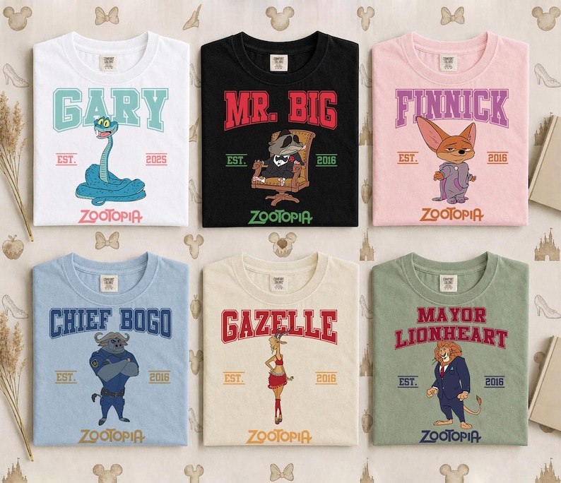 May include: Six t-shirts featuring characters from Zootopia. Each shirt displays a character's name in a collegiate font, along with the word "Zootopia" and the year "2016" or "2025". The shirts are in various colors, including white, black, pink, blue, beige, and green.