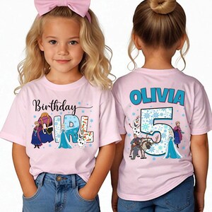 Puede incluir: Una camiseta de manga corta de color rosa claro con personajes de Frozen. El frente muestra el texto Birthday Girl con Anna, Elsa y Olaf. La parte posterior muestra el nombre Olivia, el n&uacute;mero 5 y personajes como Olaf, Sven y Elsa.