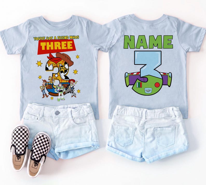 May include: Two light blue t-shirts with a Toy Story theme, featuring the number 3. One shirt has the text "You've got a friend who's THREE" and the other has "NAME" above a stylized number 3. Paired with denim shorts and checkered sneakers.