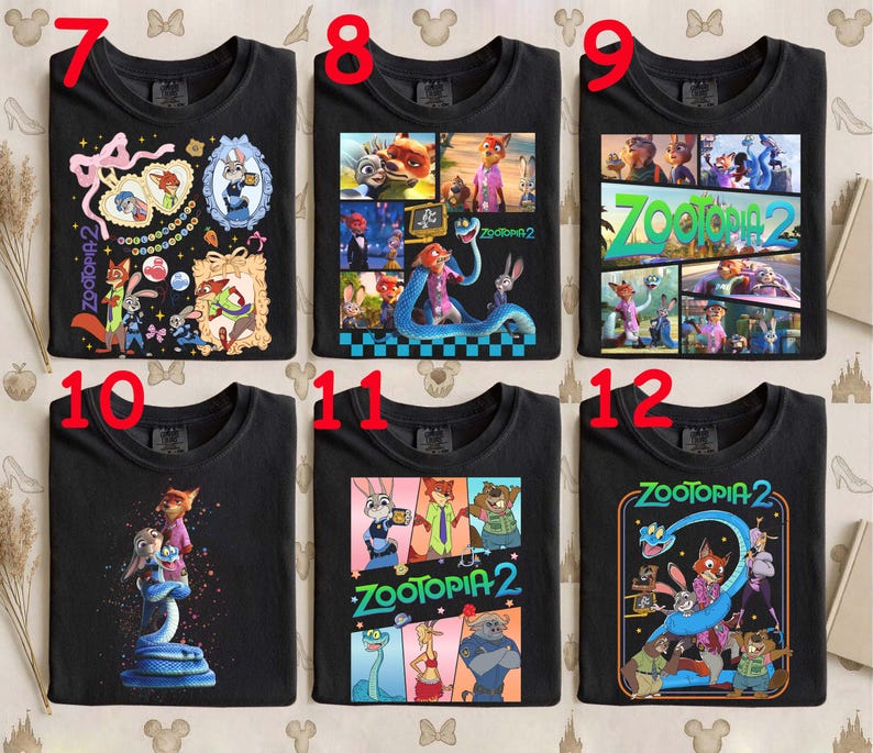 May include: Black crew neck t-shirts featuring various colorful graphics from the animated film "Zootopia 2." Designs include character collages, framed portraits, and the film's logo. The shirts are made of a soft material.