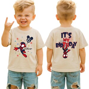 May include: A beige t-shirt featuring a Spider-Man design holding a balloon with the number 5 and the name "Oliver". The back of the shirt says "It's My Birthday" with a Spider-Man graphic. The shirt is worn by a child.