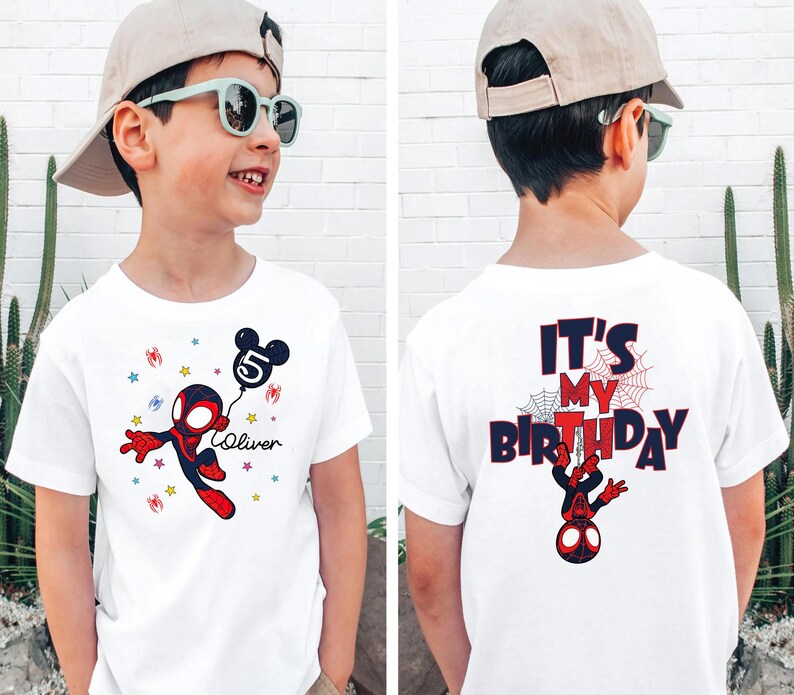 May include: White t-shirt with a Spider-Man cartoon design and a Mickey Mouse balloon with the number 5. The front has the name "Oliver" and stars. The back of the shirt says "It's My Birthday" in red and blue.
