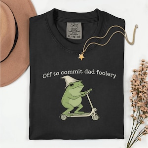 Puede incluir: Una taza de cerámica blanca con un asa negra y el texto "But First, Coffee" en negrita negra. La taza está sobre una superficie de madera. La taza mide aproximadamente 10 cm de alto.