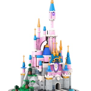 May include: A colorful toy castle constructed from interlocking blocks. The castle features pink, blue, and gold accents, with multiple turrets and a central tower. The base includes green landscaping and a white bridge.