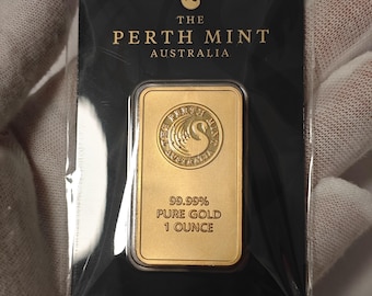 Op de afbeelding: Een rechthoekige goudbaar van 1 ounce 99,99% puur goud van The Perth Mint Australia, verpakt in een zwarte verzegelde kaart. De goudbaar heeft een cirkelvormig logo met een zwaan en de tekst 99.99% PURE GOLD 1 OUNCE.