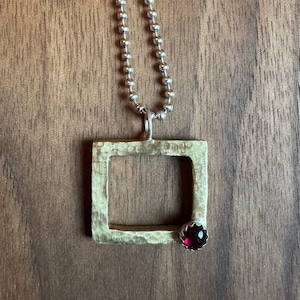 Kaaree Pendant in Brass with Garnet on sterling Silver chain.