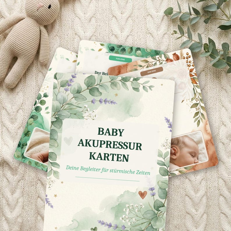 K&ouml;nnte beinhalten: Ein Set rechteckiger Karten mit dem Titel BABY AKUPRESSUR KARTEN und dem Untertitel Deine Begleiter f&uuml;r st&uuml;rmische Zeiten. Die Karten zeigen Aquarellillustrationen von gr&uuml;nen Eukalyptusbl&auml;ttern, Lavendelzweigen und kleinen Herzen auf wei&szlig;em Grund.