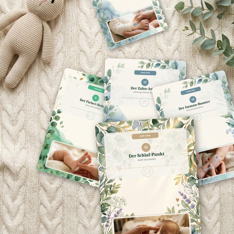 K&ouml;nnte beinhalten: Ein Set aus Anleitungskarten mit botanischen Aquarellillustrationen und Fotos von S&auml;uglingspflege-Techniken. Die Karten enthalten deutschen Text wie Der Fieber-Senker, Der Zahn-Anker, Der Immun-Booster und Der Schlaf-Punkt sowie nummerierte Beschriftungen.