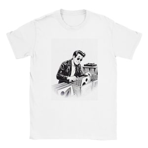 Könnte beinhalten: Ein weißes T-Shirt mit einer schwarz-weißen grafischen Illustration einer Person in Lederjacke und Sonnenbrille, die in Holzkisten nach Schallplatten stöbert, während im Hintergrund ein Plattenspieler zu sehen ist.