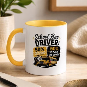 Può includere: Una tazza in ceramica bianca con interno e manico gialli. La parte anteriore presenta una grafica di uno scuolabus giallo e il testo: School Bus DRIVER: 50% DRIVING 50% PLEASE SIT DOWN. Il design include accenti neri e gialli.