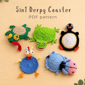 May include: Five crocheted coasters featuring animal designs including a green frog, a blue bird, a black and white penguin, a blue hippo, and a green creature with a red tongue. The text 5in1 Derpy Coaster PDF pattern is displayed at the top.