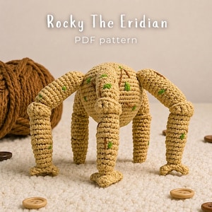 Può includere: Una creatura all'uncinetto color marrone chiaro con quattro zampe segmentate e un corpo rotondo, caratterizzata da piccoli accenti ricamati verdi. Il testo Rocky The Eridian PDF pattern è sopra l'oggetto, circondato da filato e bottoni.