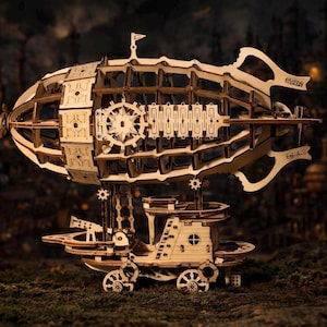 May include: A wooden model of a steampunk airship, featuring intricate cut-out designs. The airship has a large, oval-shaped body with a detailed cabin below, supported by decorative elements. The model is set against a blurred, dark background.