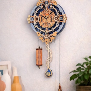 May include: A decorative wooden wall clock with a blue and gold design. The clock features Roman numerals, intricate cut-out details, and a pendulum with a teardrop-shaped weight. The clock is approximately 12 inches in diameter.