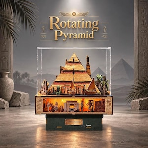 May include: A Rotating Pyramid display piece encased in a clear acrylic box. The pyramid features golden textures, miniature boats, and palm trees. The base contains an illuminated chamber with small figures and the text Desert Journey Type-c.