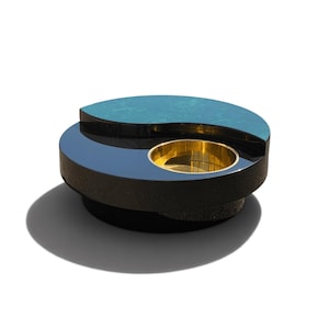 Peut inclure: Une table basse circulaire présentant un design à plateau divisé, avec une moitié en finition sarcelle lisse et l'autre moitié en finition noire brillante. Un bol circulaire encastré en or poli est intégré dans la section noire de la table.