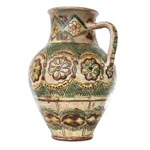 May include: A vintage ceramic pitcher with a handle, featuring hand-painted floral and geometric patterns in shades of green, yellow, brown, and red. The pitcher has a wide base, a rounded body, and a narrow neck.