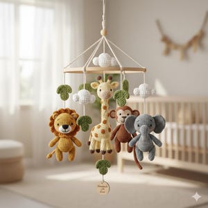 May include: A handmade crochet baby mobile featuring a lion, giraffe, monkey, and elephant. The mobile includes white clouds and green leaf accents, suspended from a wooden frame. The mobile is designed for a nursery.