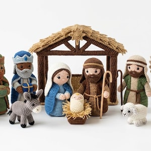 May include: A crocheted nativity scene with figures of the Three Wise Men, Mary, Joseph, baby Jesus, an angel, a donkey, a sheep, and a camel. The figures are in various colours, including purple, green, blue, brown, and white. A brown crocheted stable is in the background.
