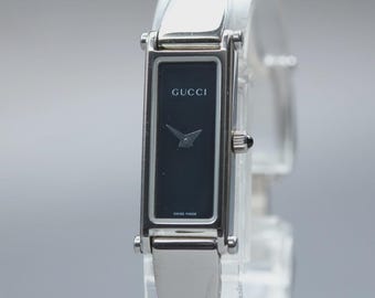 Reloj de mujer GUCCI 1500L vintage [casi nuevo] de cuarzo con esfera negra y 12 mm, color plata.
