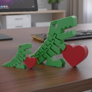 May include: Two green dinosaur sculptures, one large and one small, each holding a red heart. The dinosaurs are on a wooden surface. The larger dinosaur is approximately 6 inches tall.