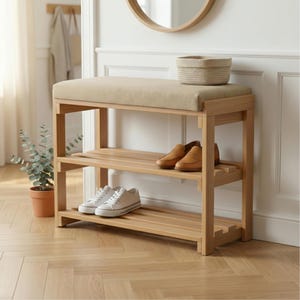 以下が含まれることがあります： ベージュのクッションシートと2つの棚が付いた、明るい木製の靴ベンチ。棚には茶色の革のローファーと白いスニーカーが置かれています。ベンチには織りのバスケットが置かれています。ベンチは明るい色の木材で作られています。