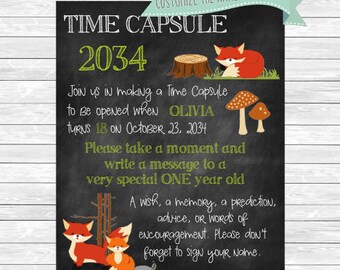 May include: A black chalkboard sign with a green and white banner at the top that says "Customize the name and dates!" The sign says "Time Capsule 2034" and has a fox illustration. The sign says "Join us in making a Time Capsule to be opened when Olivia turns 18 on October 23, 2034. Please take a moment and write a message to a very special ONE year old. A wish, a memory, a prediction, advice, or words of encouragement. Please don't forget to sign your name."