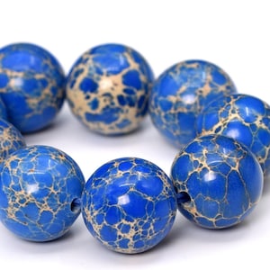 May include: A strand of blue and white jasper beads. The beads are round and have a marbled pattern.