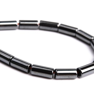May include: A black hematite bracelet with cylindrical beads.