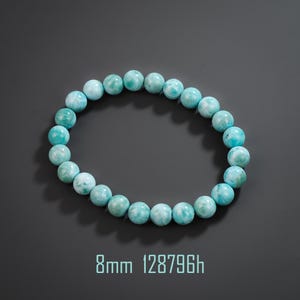 May include: A circular stretch bracelet composed of round, polished light blue and white marbled beads. Each bead measures 8mm in diameter. The text 8mm 128796h is printed in light blue at the bottom of the frame, indicating the bead size.