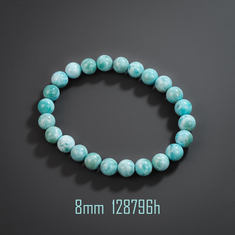 May include: A circular stretch bracelet composed of round, polished light blue and white marbled beads. Each bead measures 8mm in diameter. The text 8mm 128796h is printed in light blue at the bottom of the frame, indicating the bead size.