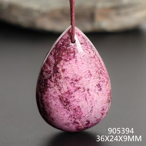 May include: A teardrop-shaped pendant with a pink and burgundy mottled pattern, suspended by a burgundy cord. The pendant measures approximately 1.4 inches long, 0.9 inches wide, and 0.35 inches thick. The text "905394" and "36X24X9MM" are visible.