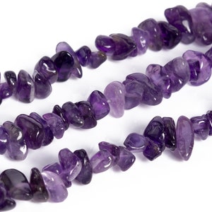 May include: A strand of purple amethyst gemstone chips. The chips are irregular in shape and have a smooth, polished finish.