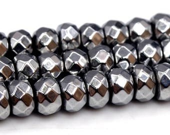 May include: A strand of faceted, silver-toned hematite beads. The beads are round and have a slightly irregular shape.