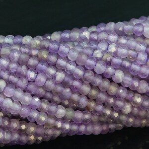 May include: A strand of faceted amethyst beads in a light purple colour. The beads are round and have a smooth, polished finish.