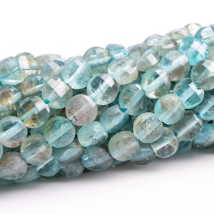 May include: A strand of light blue aquamarine gemstone beads. The beads are faceted and have a slightly irregular shape.